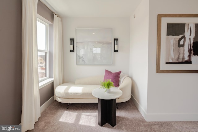 sitting room featuring carpet flooring, baseboards, and a healthy amount of sunlight