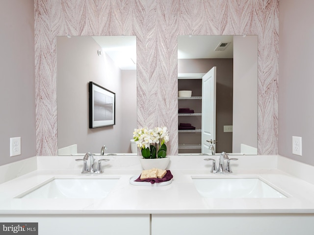 full bath with double vanity, visible vents, and a sink