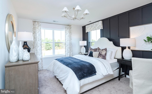 bedroom with a chandelier, visible vents, and light carpet