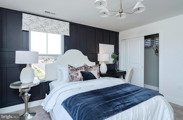 carpeted bedroom with a chandelier, visible vents, a closet, and baseboards