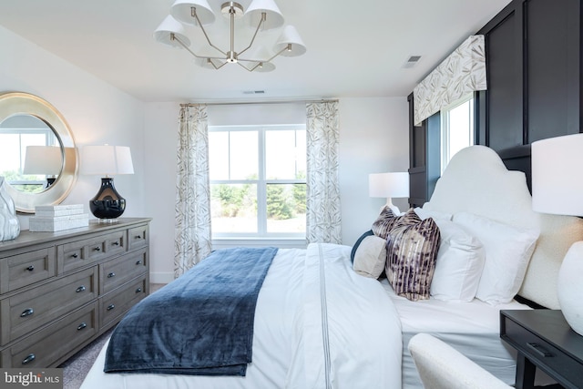 bedroom with visible vents and a notable chandelier