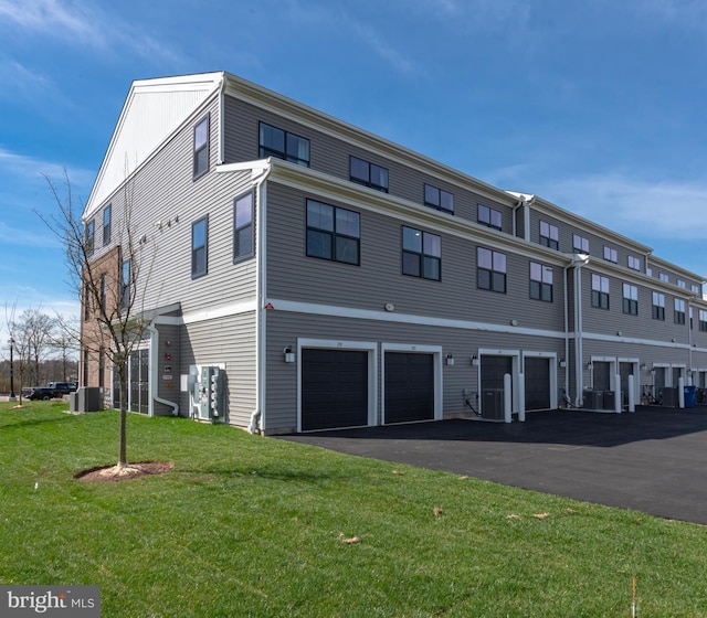 exterior space with cooling unit, driveway, and a garage