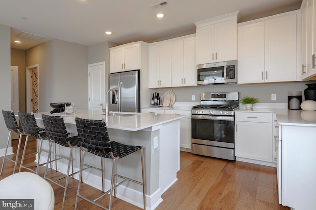 kitchen featuring appliances with stainless steel finishes, visible vents, and white cabinets