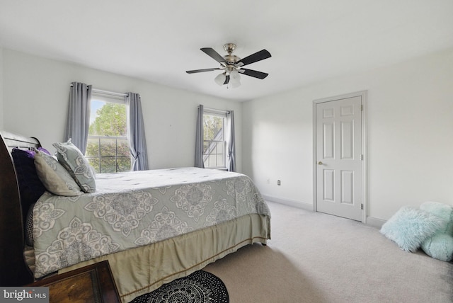 carpeted bedroom with a ceiling fan and baseboards