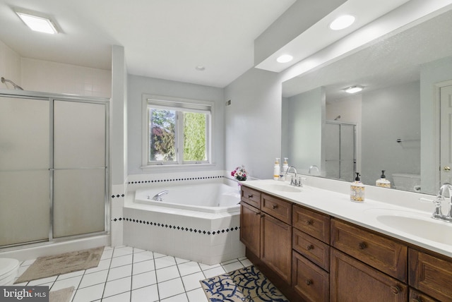 bathroom featuring a garden tub, a sink, tile patterned flooring, and a stall shower
