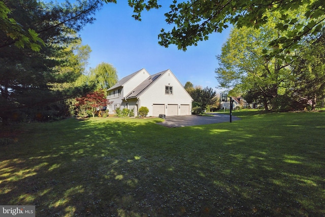view of side of home featuring a lawn and an attached garage