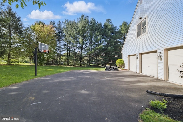 view of property exterior with a garage, a lawn, and aphalt driveway