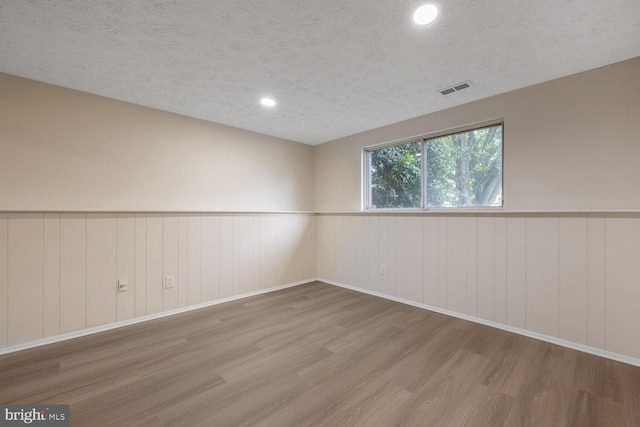 2909 Golden Fleece Dr, Pasadena, MD 21122 - empty room with wood finished floors, a wainscoted wall, a textured ceiling, and recessed lighting