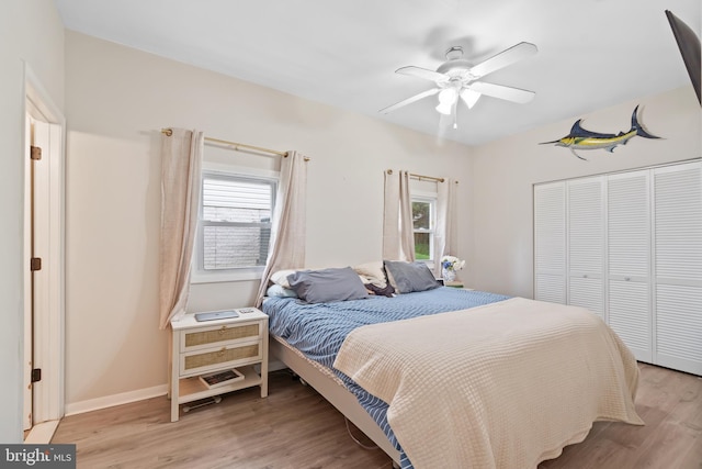 bedroom featuring light wood-style floors, a closet, and multiple windows