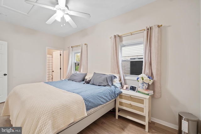 bedroom featuring a ceiling fan, baseboards, and wood finished floors