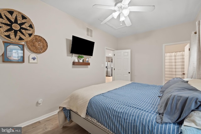 bedroom featuring a ceiling fan, visible vents, wood finished floors, stainless steel fridge with ice dispenser, and baseboards