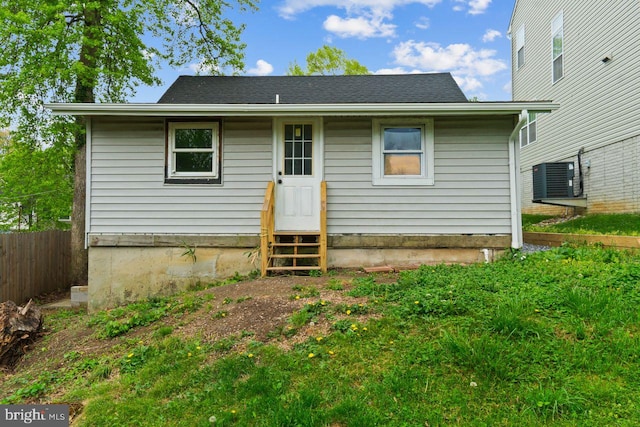 back of property featuring entry steps, fence, and central AC