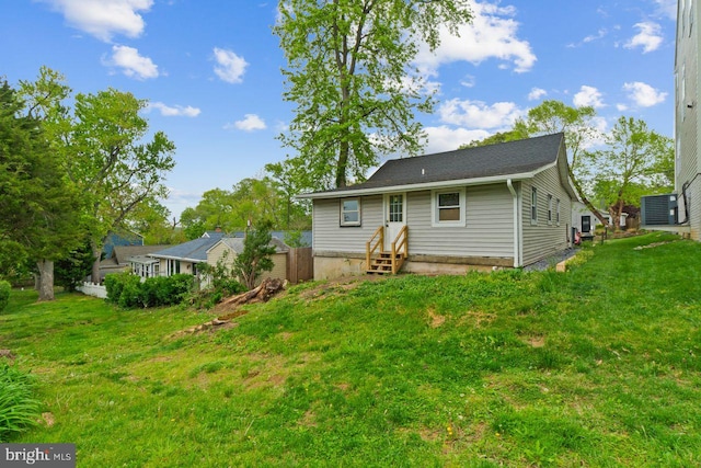 rear view of property featuring a yard and entry steps