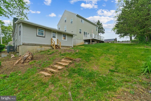 rear view of house featuring entry steps, central air condition unit, and a lawn