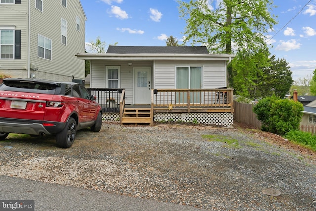 view of front of house with fence, a shingled roof, and a porch