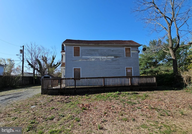 rear view of house with a deck and fence