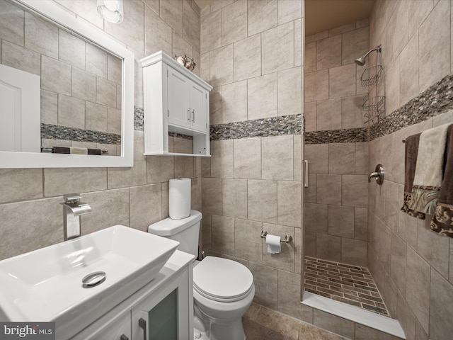 bathroom featuring tile walls, a stall shower, toilet, and vanity