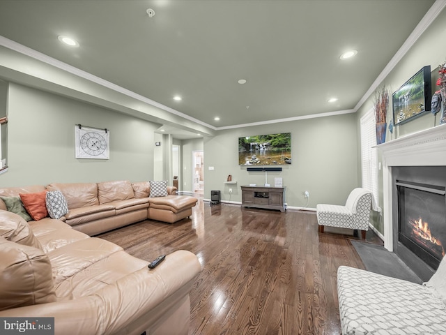 living area with wood finished floors, a fireplace with flush hearth, recessed lighting, crown molding, and baseboards