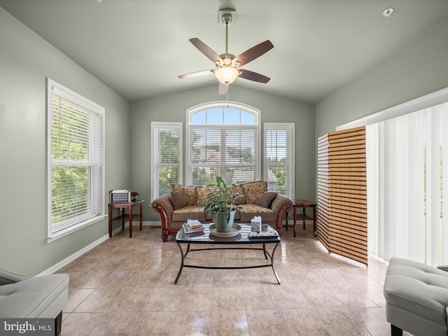 living room featuring lofted ceiling, ceiling fan, and baseboards
