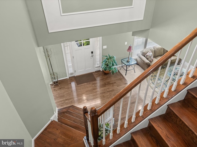 entryway featuring wood finished floors, stairs, and baseboards