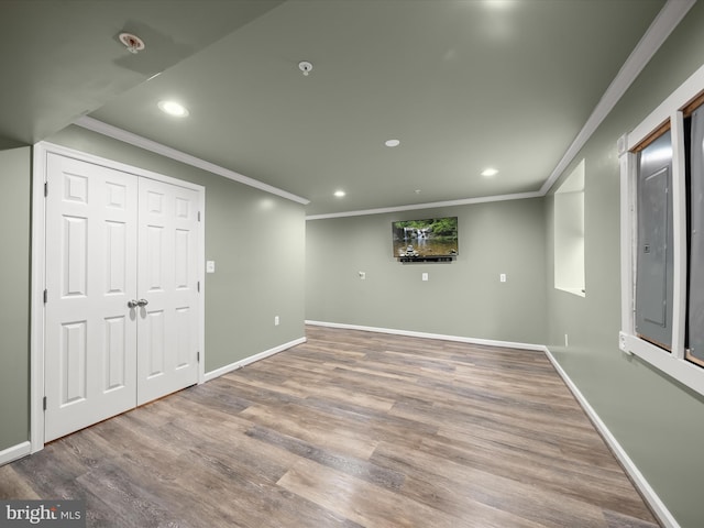below grade area with crown molding, recessed lighting, wood finished floors, and baseboards
