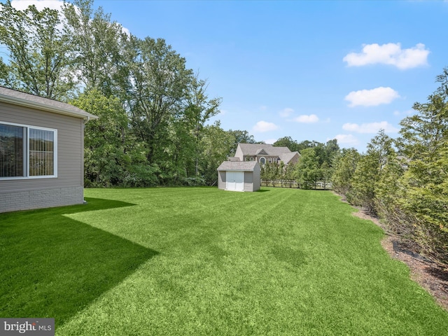 view of green lawn featuring a storage unit and an outbuilding