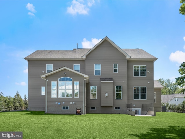 rear view of house featuring a lawn and cooling unit