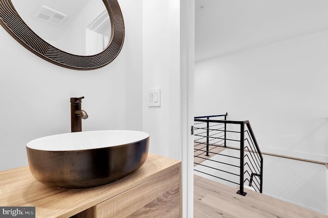 bathroom featuring visible vents, a sink, and wood finished floors