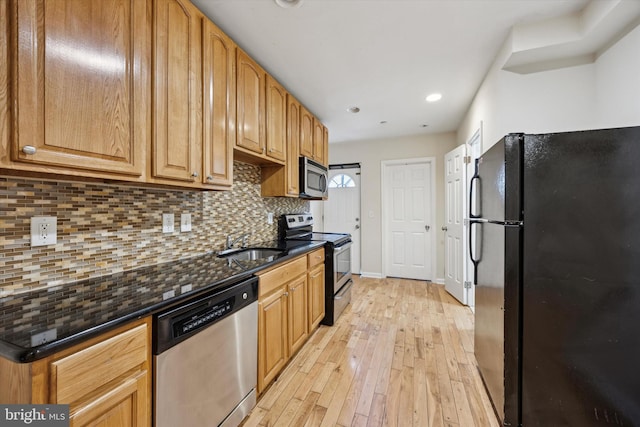 1931 N Uber St, Philadelphia, PA 19121 - kitchen featuring appliances with stainless steel finishes, light wood-style floors, decorative backsplash, recessed lighting, and dark stone counters