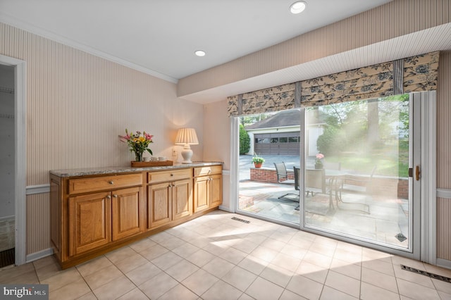 doorway to outside featuring crown molding, light tile patterned floors, wallpapered walls, and visible vents