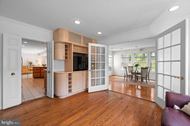 living area featuring french doors, ornamental molding, wood finished floors, and recessed lighting
