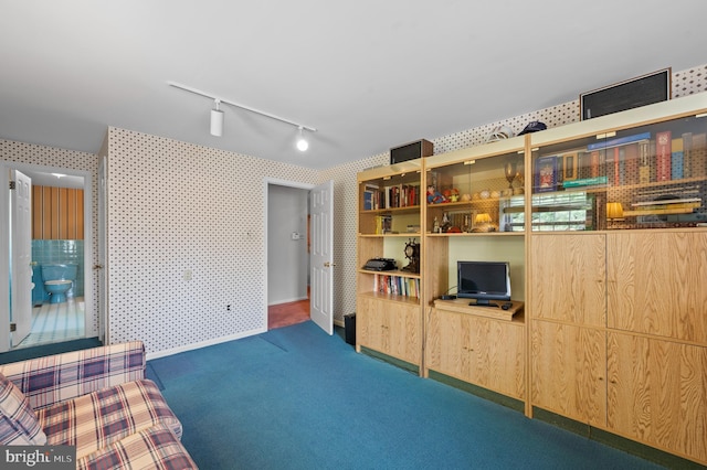 interior space featuring track lighting, carpet, and wallpapered walls