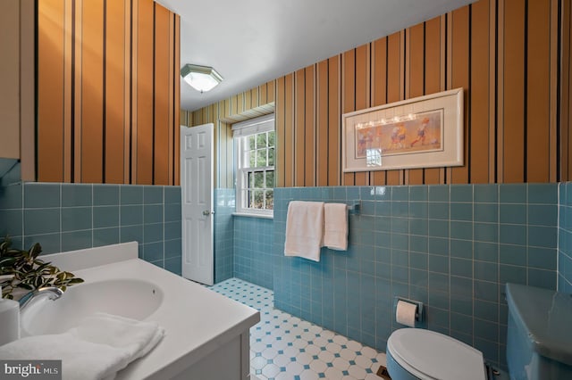 bathroom featuring tile walls, vanity, and toilet