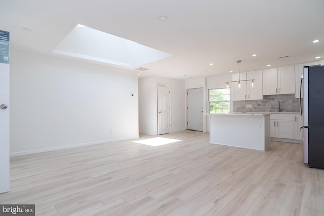 2 Edgewood Ln, Levittown, PA 19054 - kitchen with decorative backsplash, a center island, white cabinets, freestanding refrigerator, and open floor plan