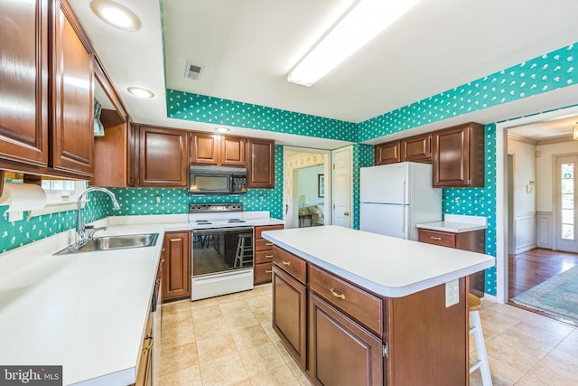2707 E Crossing Cir, Norristown, PA 19403 - kitchen featuring white appliances, a sink, wallpapered walls, light countertops, and a center island