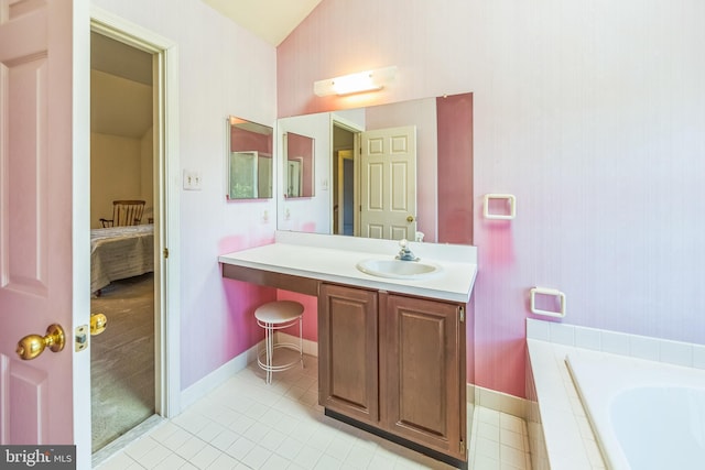 2707 E Crossing Cir, Norristown, PA 19403 - ensuite bathroom featuring tile patterned flooring, vanity, a relaxing tiled tub, lofted ceiling, and baseboards