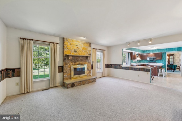 2707 E Crossing Cir, Norristown, PA 19403 - living area featuring light carpet, healthy amount of natural light, and a stone fireplace