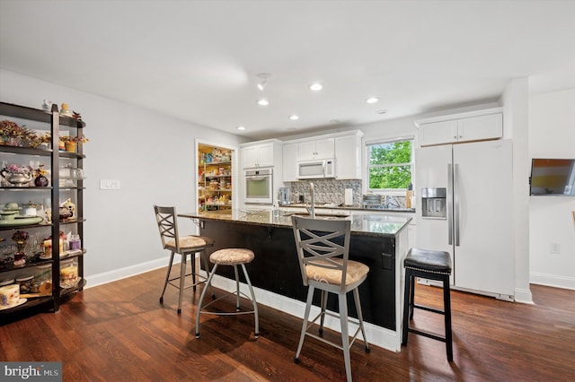 628 Edge Hill Rd, Glenside, PA 19038 - kitchen with white appliances, a kitchen breakfast bar, dark stone counters, dark wood-type flooring, and recessed lighting