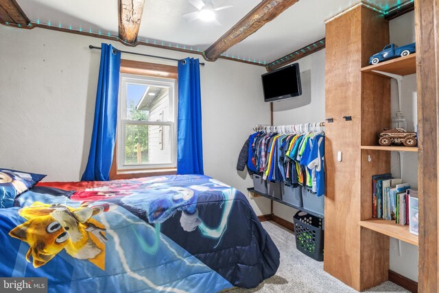 bedroom with baseboards, carpet, and beam ceiling