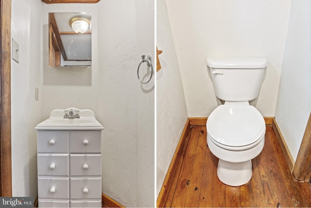 half bathroom featuring vanity, wood finished floors, and toilet