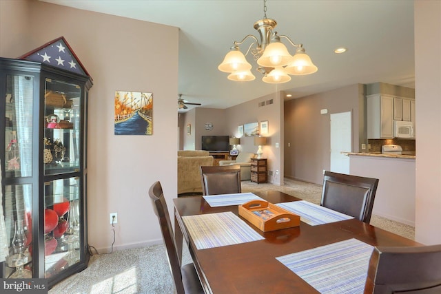 dining space with baseboards, light carpet, ceiling fan with notable chandelier, and visible vents