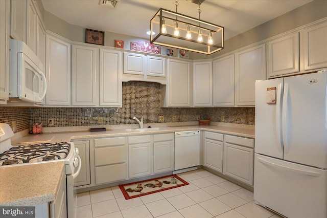 kitchen with white appliances, white cabinets, a sink, and light countertops