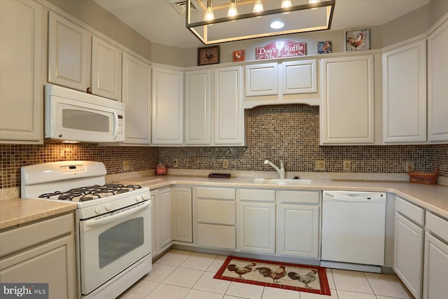 kitchen featuring white appliances, light countertops, white cabinets, tasteful backsplash, and a sink