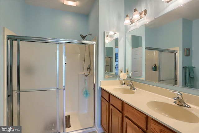 full bathroom featuring double vanity, a sink, and a stall shower
