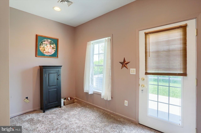 doorway with visible vents, baseboards, plenty of natural light, and carpet floors