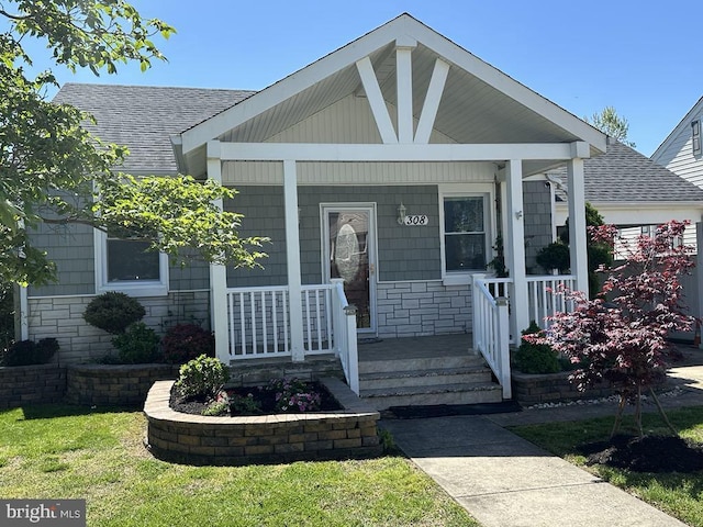 view of front facade with a porch and a shingled roof