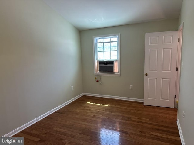 empty room with baseboards, dark wood-style floors, and cooling unit