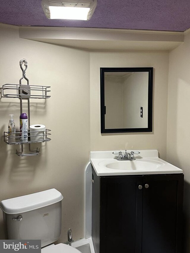 half bathroom featuring vanity and toilet