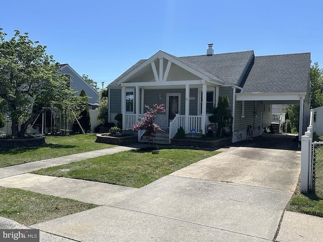 bungalow-style home featuring roof with shingles, covered porch, driveway, and a front lawn