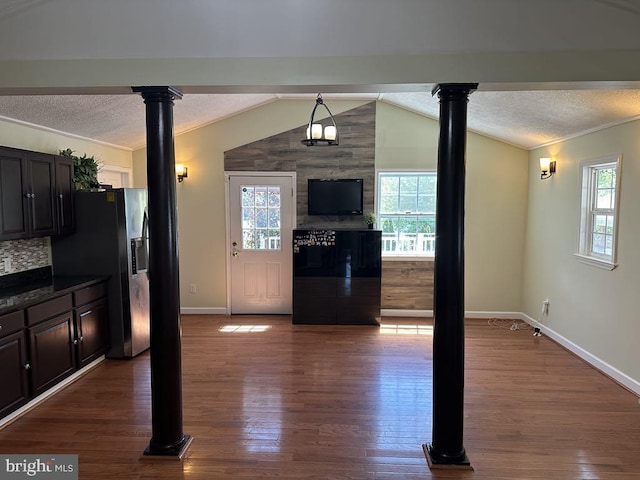 interior space with dark wood-style flooring, baseboards, vaulted ceiling, and a textured ceiling